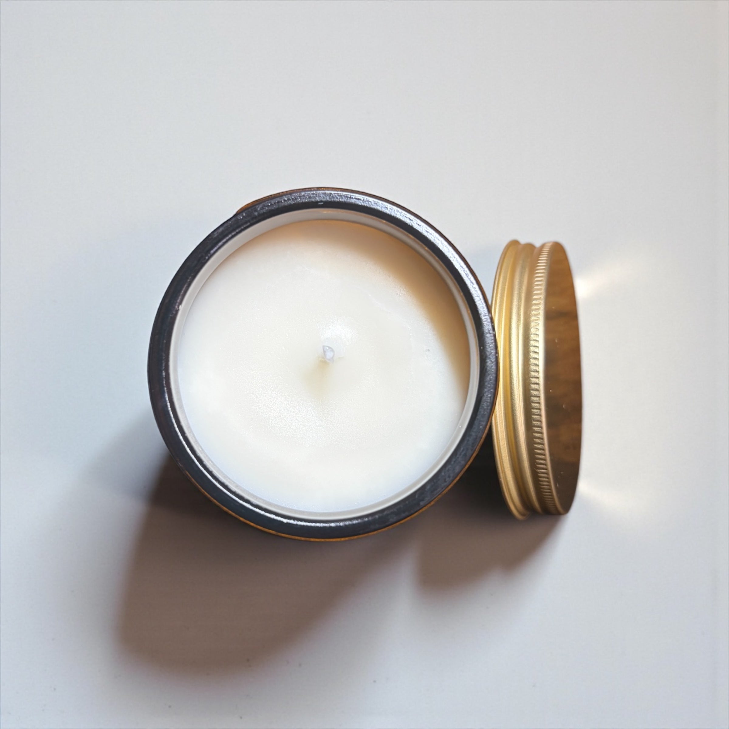 Bird’s eye view of NuVibe lavender fields soy wax candle in amber glass jar, natural essential oil home fragrance candle styled with lavender, clean minimalist flat lay